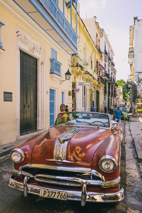Красный автомобиль, припаркованный на улице на Кубе - как заработать на фотографии