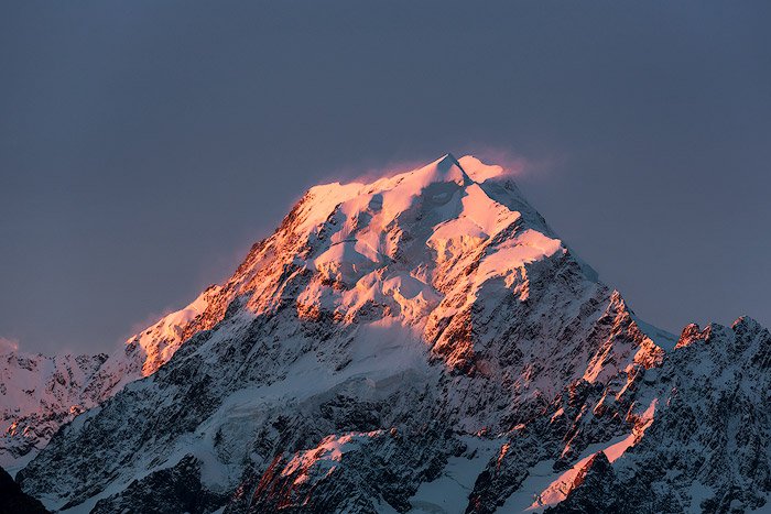 Icy mountain peak photo shoot with pink light reflect on snow