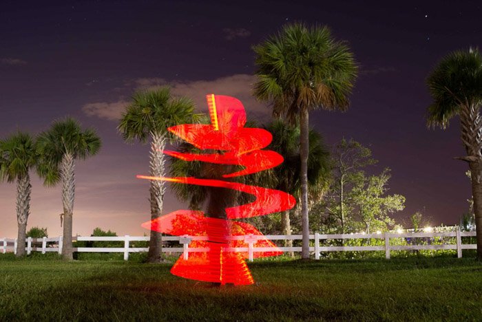 Пальма, окруженная красной спиралью световой картины