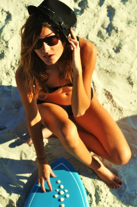 Женщина позирует на пляже для модельной съемки