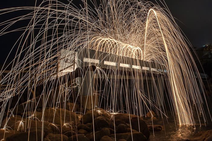Атмосферный и захватывающий пример фотографии стальной ваты вокруг здания ночью