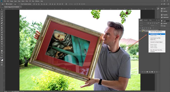 Скриншот Photoshop, редактирующий фотографию мужчины, держащего картину в рамке