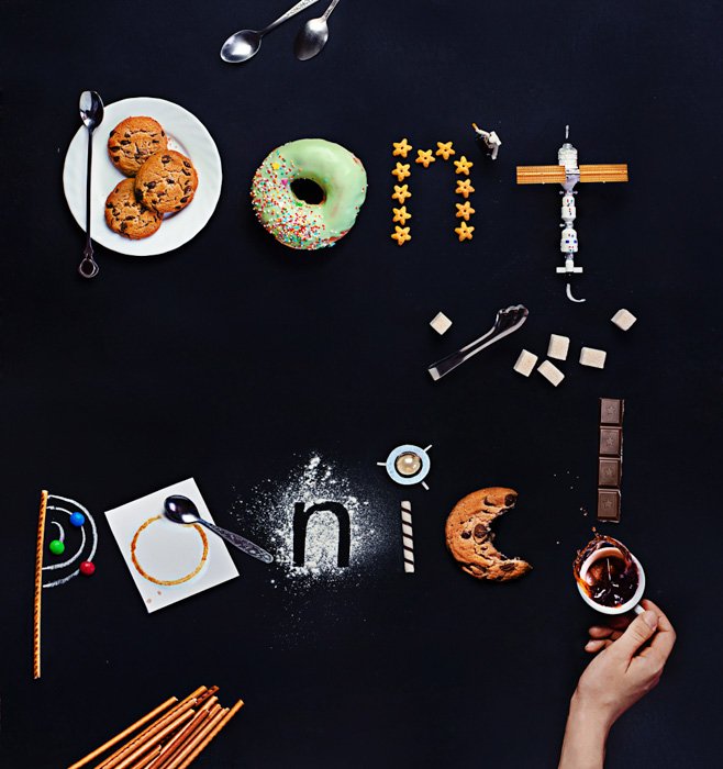 Снимок сверху с изображением кофейных чашек, столовых приборов, игрушек, блюдец, бисквитов и другого реквизита для фуд-арта с надписью 