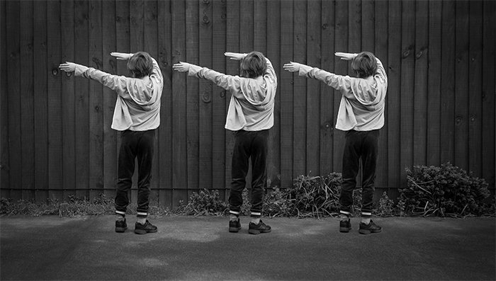 Пример черно-белой многоплановой фотографии трех одинаковых маленьких девочек, танцующих на улице