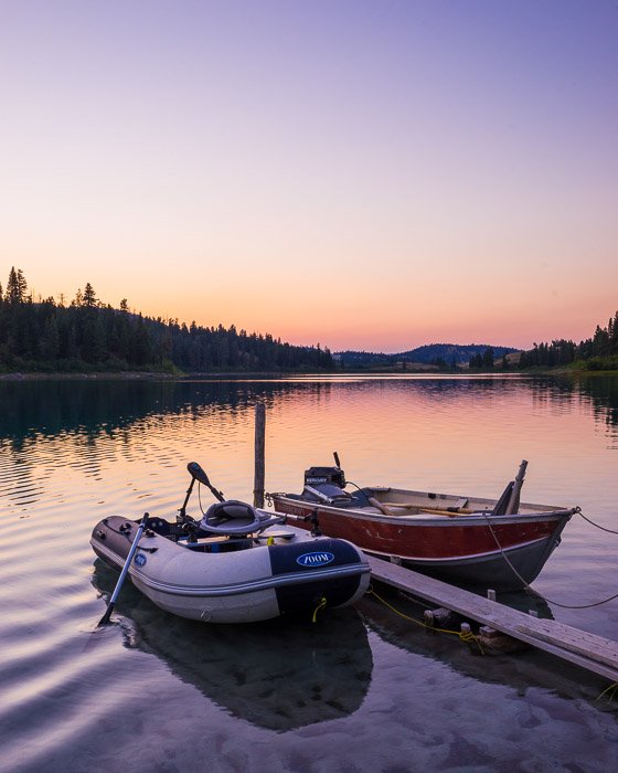 Фотоснимок дорожной поездки двух небольших лодок, привязанных на озере в вечернее время