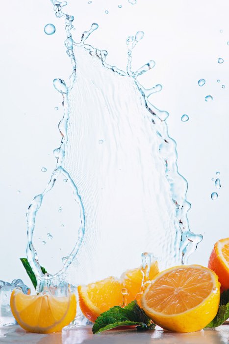 Забавный фуд-фотоснимок апельсинов с застывшими над ними брызгами прохладной воды