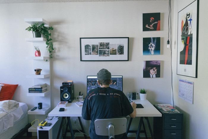 Мужчина редактирует фотографии на ноутбуке в домашнем офисе