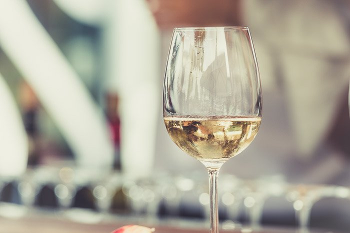 Советы по стилизации блюд: Бокал белого вина на размытом фоне