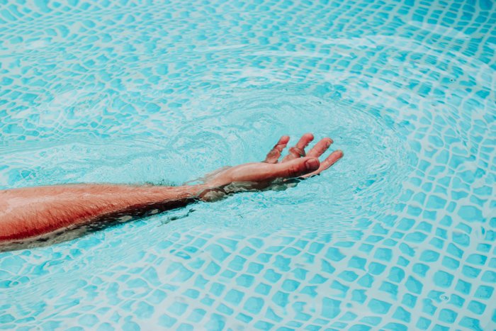 Рука человека, распростертая в воде с использованием оранжевой и синей цветовой схемы
