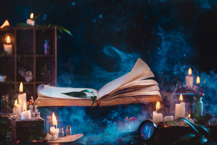 Жутковатый фотонатюрморт на Хэллоуин с использованием книги заклинаний, свечей и другого реквизита