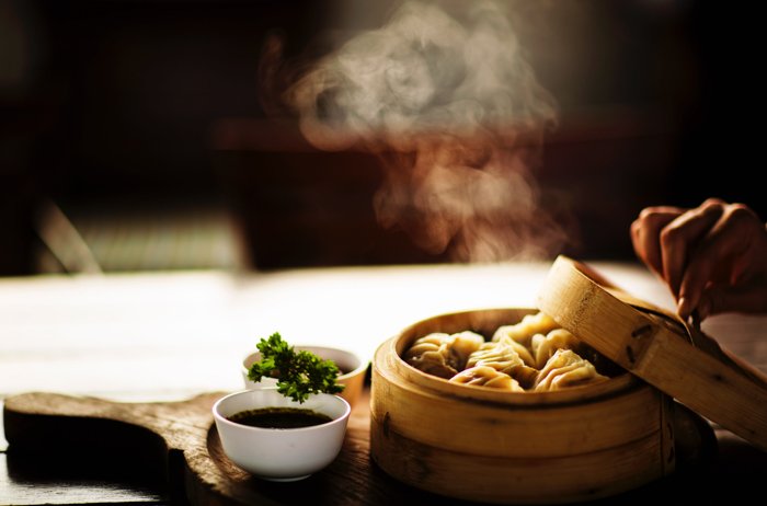 food photography of steamy dumplings on the wooden tray