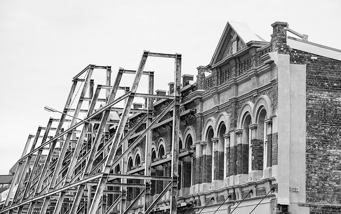 Черно-белая фотография старого здания старой архитектуры, строительные леса прислонены к его торцу - монтаж черно-белых фотографий