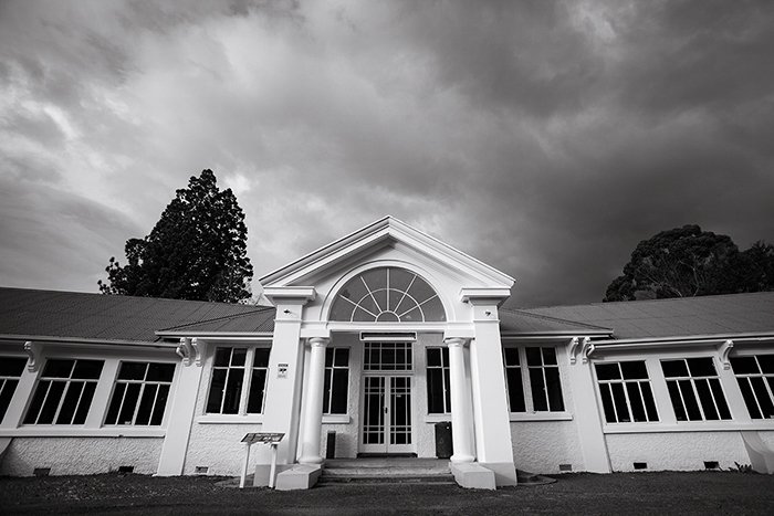 Черно-белая фотография арочного входа в палату Чишолма в больнице Королевы Марии в Ханмере, Новая Зеландия - монтаж черно-белого фото