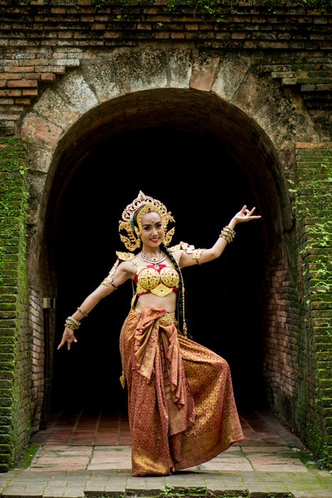 Красиво одетый улыбающийся тайский танцор позирует перед туннелем - советы по композиции фотографии