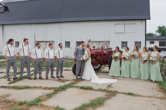 Большая свадебная вечеринка позирует на открытом воздухе во дворе фермы - фокус камеры для резкой групповой фотографии