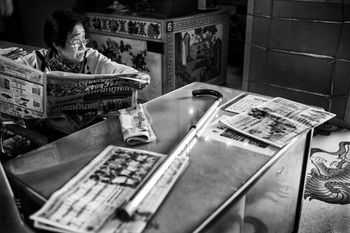 черно-белый портрет женщины, читающей газету за столом