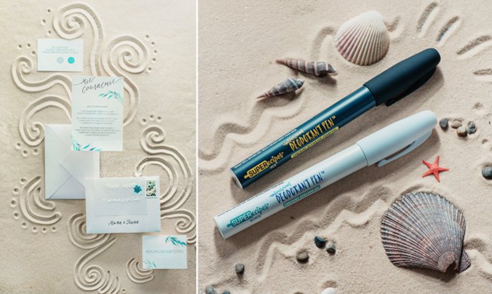 минималистичные приглашения и конверты, ракушки и художественные маркеры на мелком коричневом песке. вьющиеся веселые узоры прорисованы на песке вокруг них.