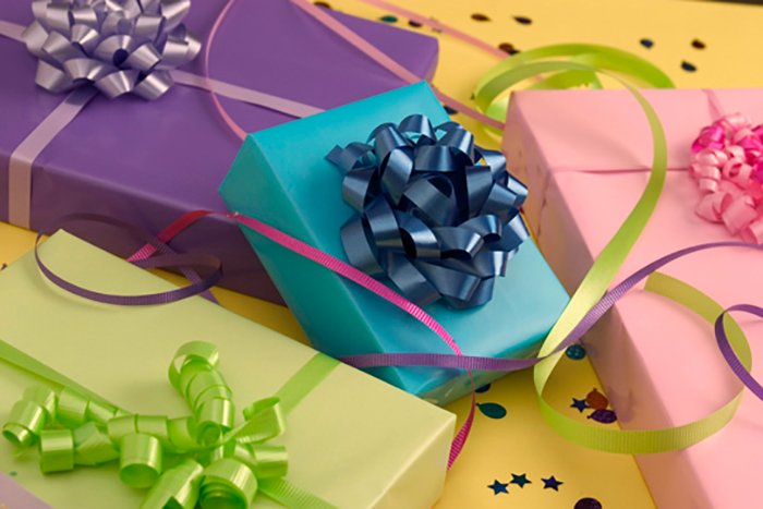 Снимок натюрморта из подарков на день рождения, завернутых в разноцветную бумагу и праздничные серпантины