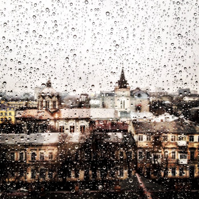 Городской пейзаж, увиденный сквозь забрызганное дождем окно