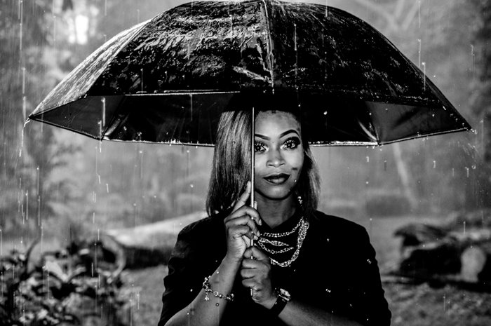 черно-белый портрет женщины, держащей зонтик под дождем
