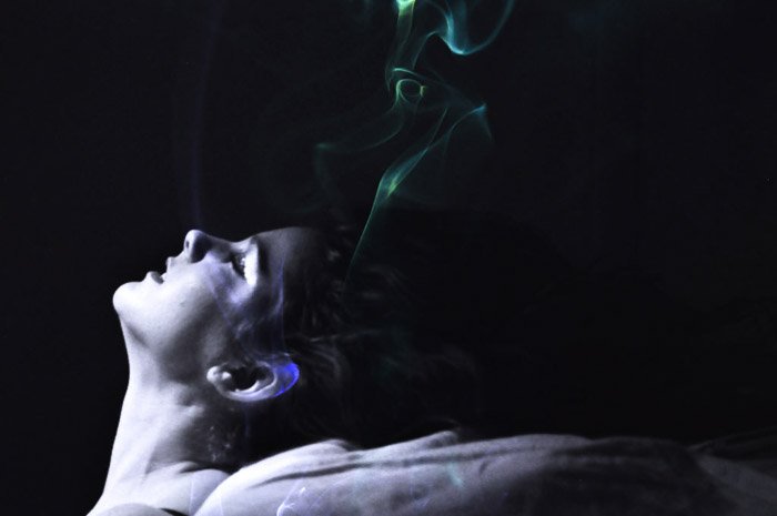 атмосферный и загадочный портрет девушки с зеленым дымом у головы - теневая фотография