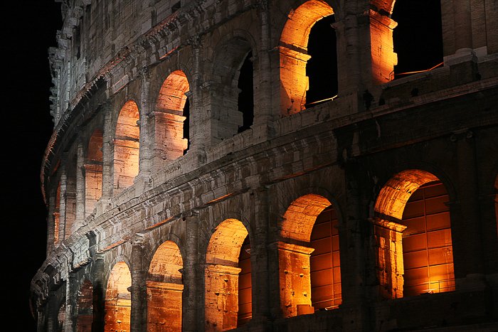 Колизей в Италии, освещенный изнутри теплым оранжево-желтым светом, светящимся в ночи