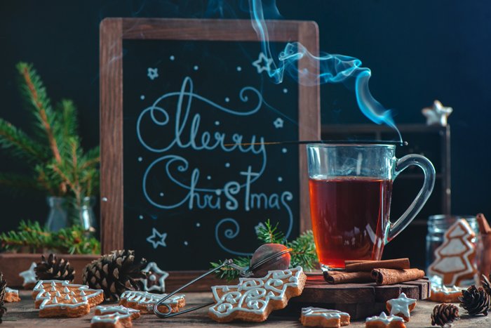 Горячий чай, печенье и доска с рождественскими поздравлениями