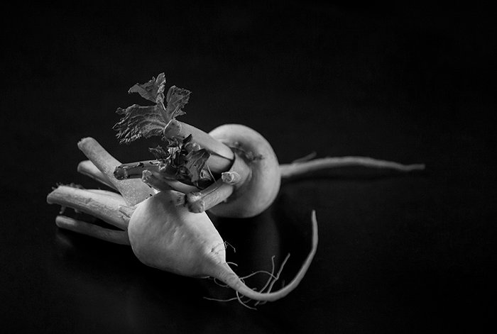 A black and white food still life shot of vegetables