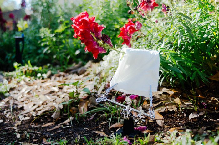 Снимок белого полотенца, разложенного среди цветов и растений, для улучшения цветочных фотографий
