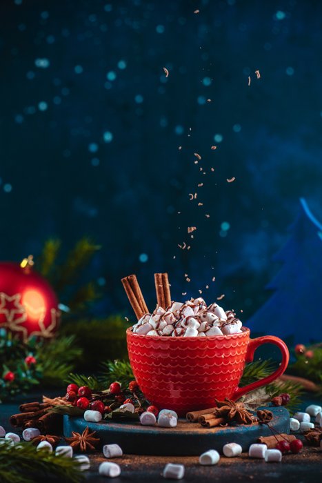Прикольный рождественский фото натюрморт шоколадных крошек, левитирующих над чашкой горячего шоколада в натюрморте