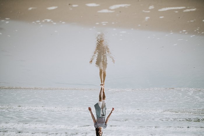 Художественная фотография девушки на пляже под перевернутым углом - 