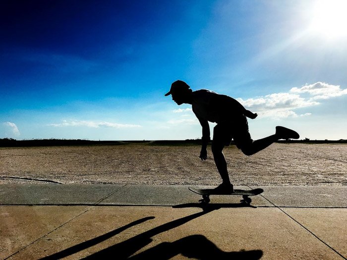 Силуэт скейтбордиста в действии, снятый с помощью фотовспышки на iphone
