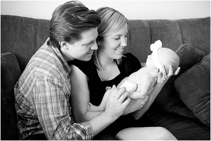 A black and white lifestyle shot of the couple with their baby - newborn photography business tips