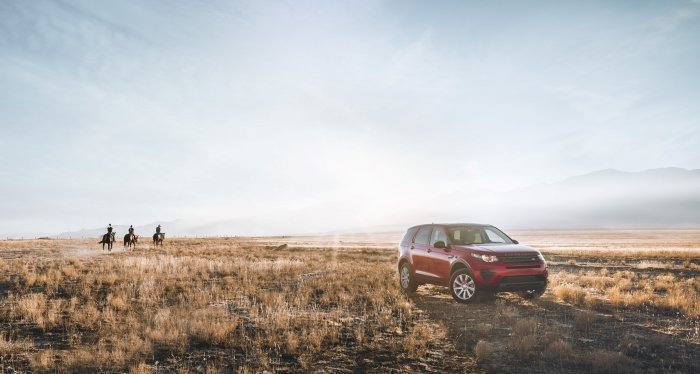 Product photo of the car in the country landscape with people on horses