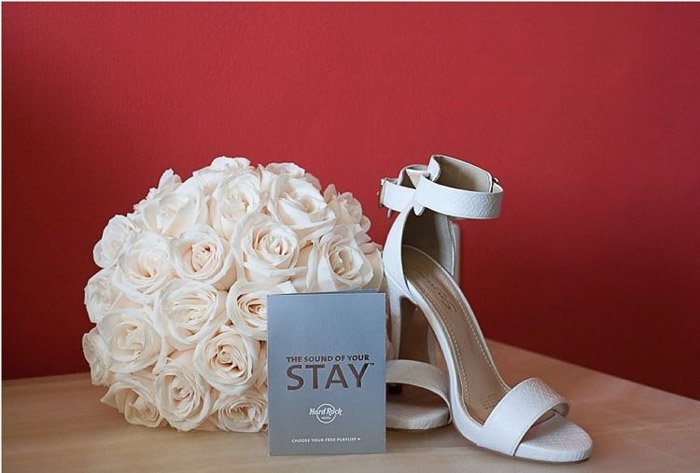 Натюрморт для свадебной фотографии с изображением пары туфель, цветов и буклета