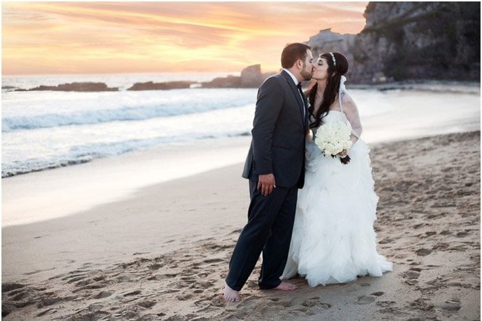 Romantic destination wedding portrait of the couple kissing on the beach