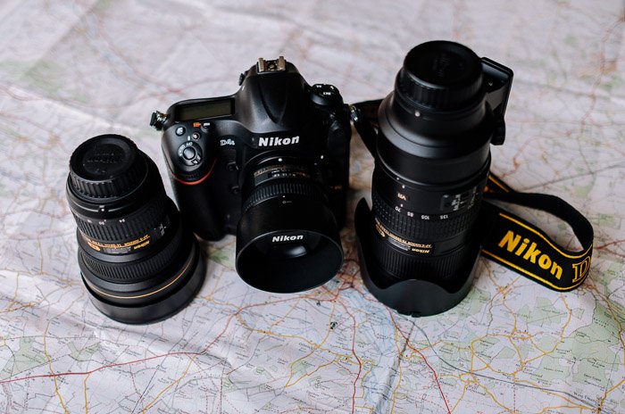 Камера Nikon и объективы лежат на карте