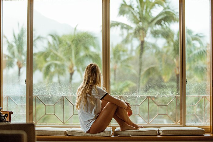 A candid lifestyle shot of a female model looking out of a window 