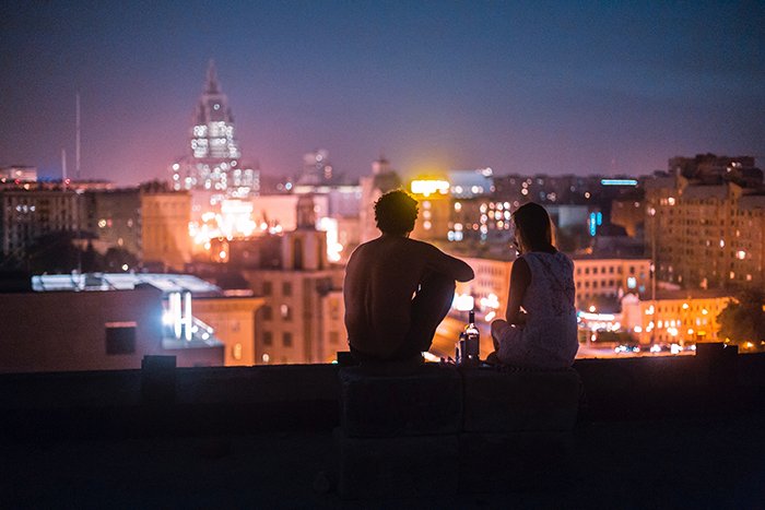 Пример откровенной фотографии пары, сидящей на крыше высокого здания ночью - 