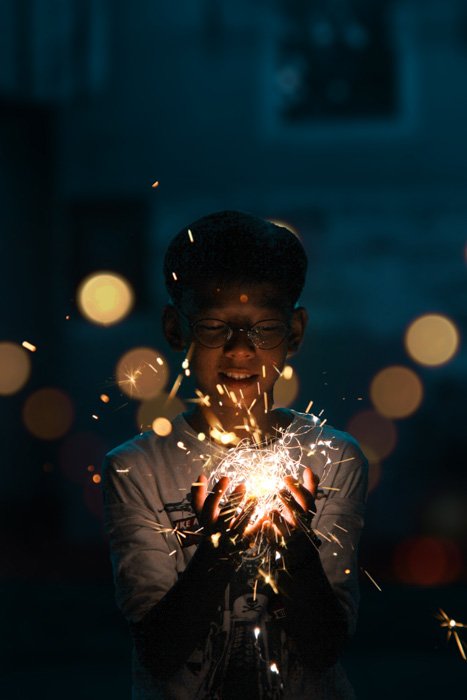Портрет молодого парня, держащего вереницу мерцающих огней, снятый с помощью фотобудки DIY