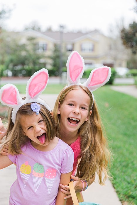 Sweet easter portrait photo of two little girls in bunny ears posing outdoors