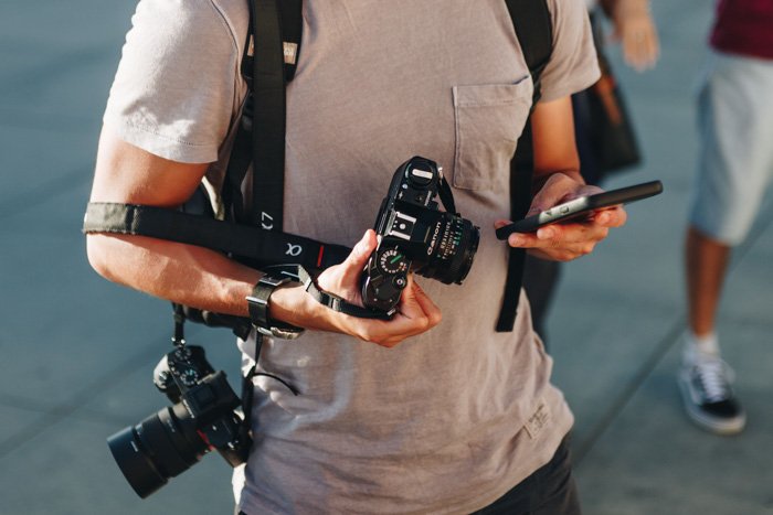 изображение уличного фотографа, держащего 35-мм пленочную камеру