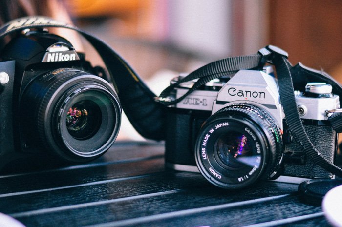 Canon и Nikon 35-мм пленочная фотокамера на столе