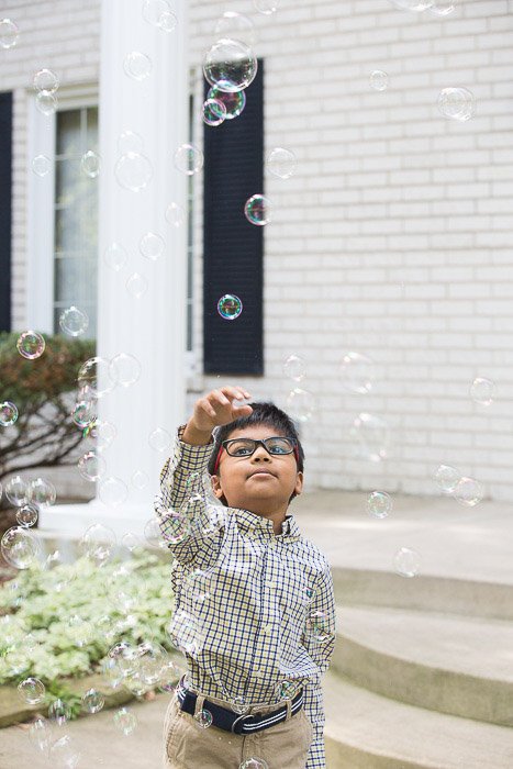Outdoor portarit of the young boy playing with bubbles