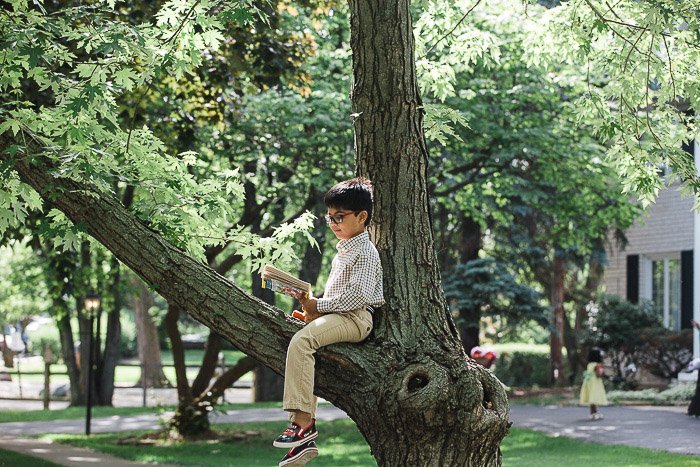 Портрет на природе мальчика, сидящего на дереве - идеи семейных фотографий для вдохновения