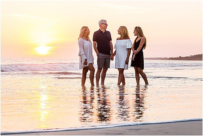 Сладкий портрет семьи из четырех человек, позирующей на пляже на закате - эмоциональная фотография