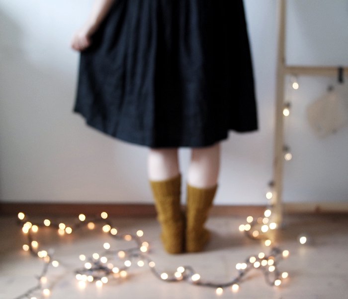 blurry indoor portrait of the female model standing in front of the string of lights - fairy light photography