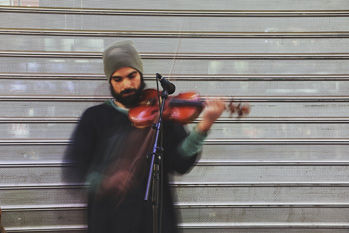 Blurry portrait of the street performer playing violin - fine art photography mistakes 