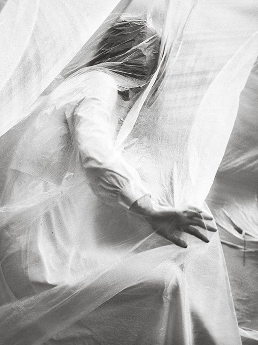 Концептуальный портрет женской модели, покрытой материалом, снятый в черно-белом цвете