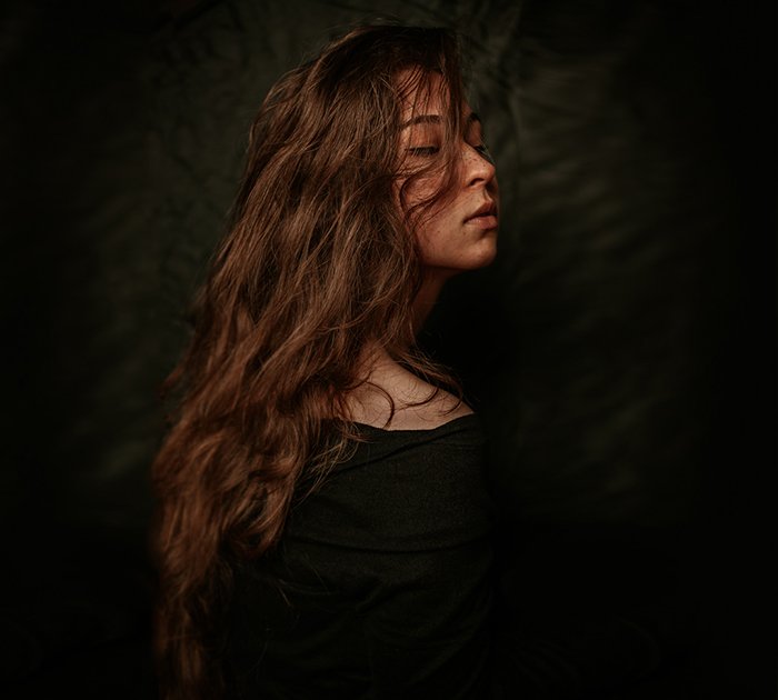 Атмосферный автопортрет женщины-модели, позирующей на черном фоне - ошибки изобразительного искусства фотографии